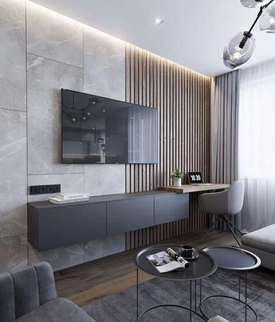 Modern living room featuring stone wall wooden slats floating cabinet desk chair and coffee tables