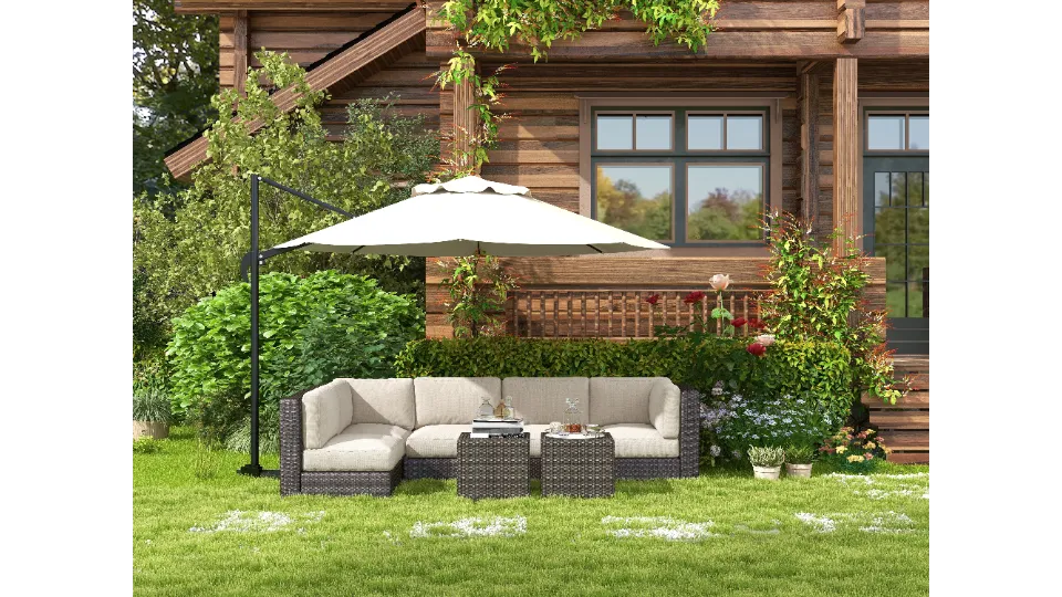 White patio umbrella above beige sofa on green grass next to a brown wooden house