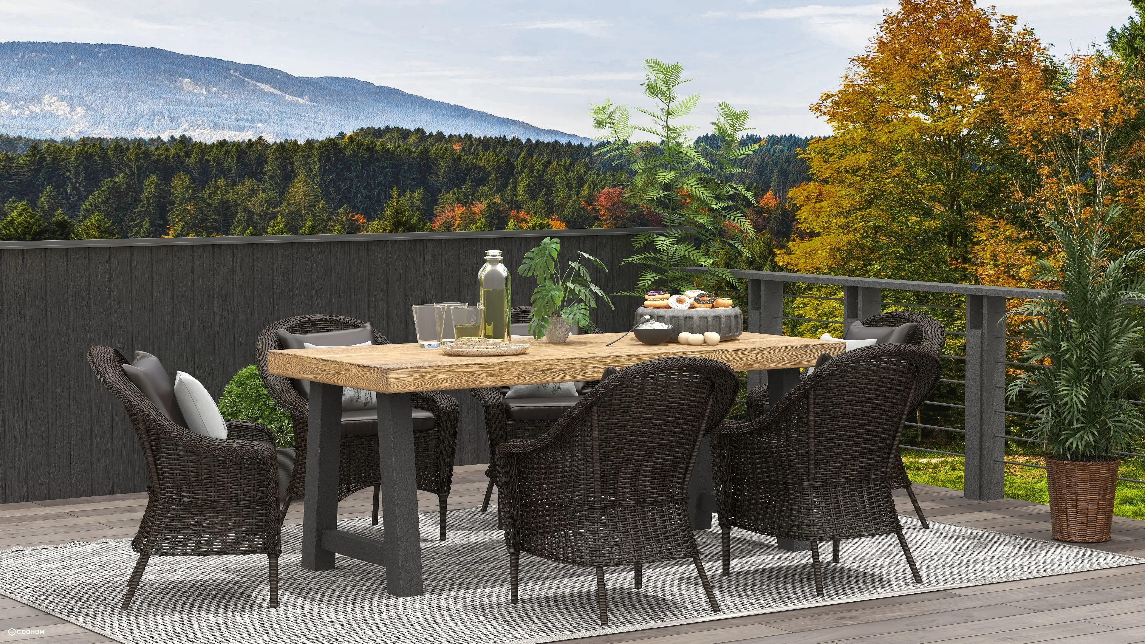 Outdoor patio area with a wooden table, dark wicker chairs, green plants, and mountain views
