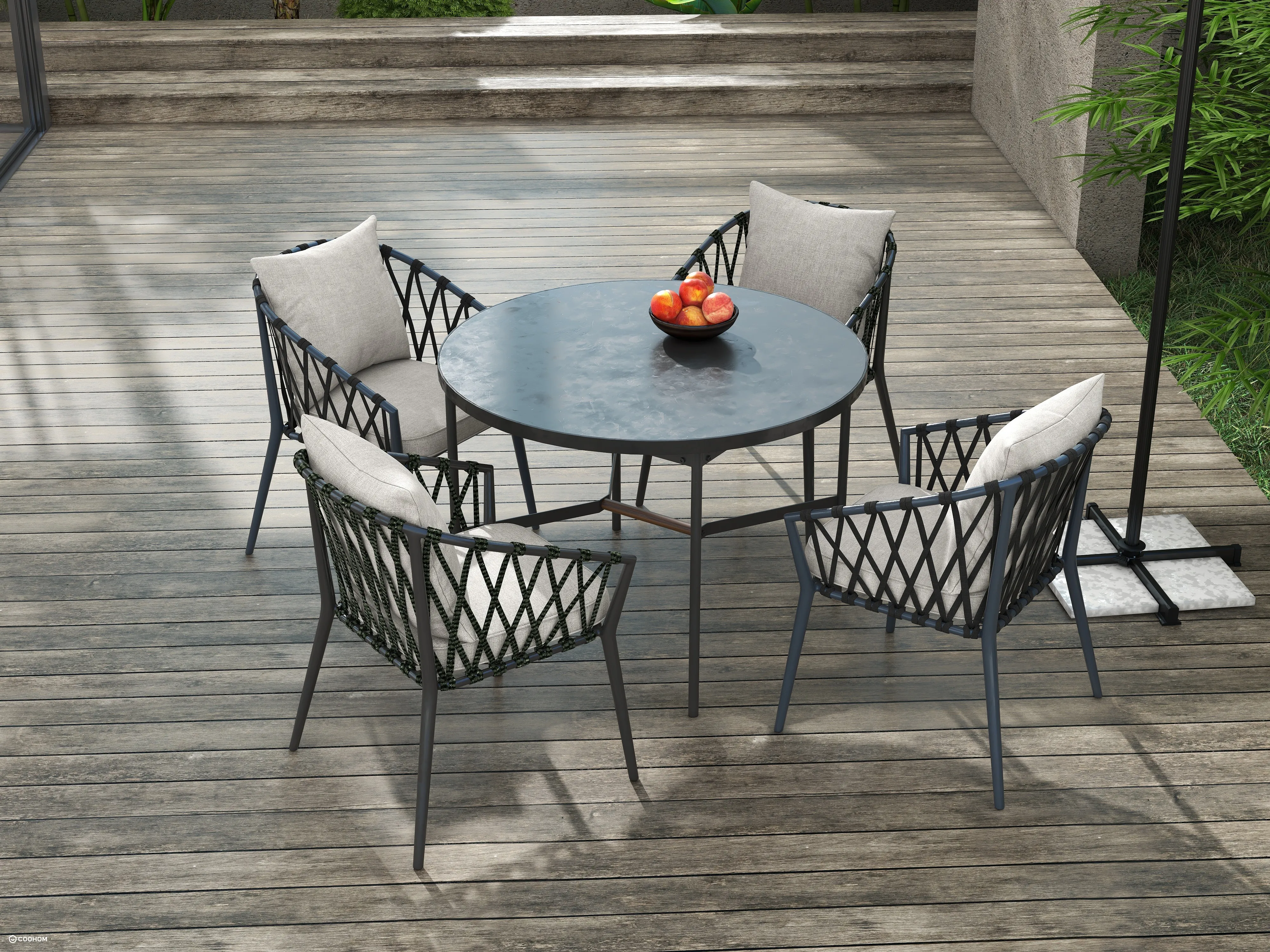 Four black outdoor chairs with grey cushions surrounding a round table on a wooden deck