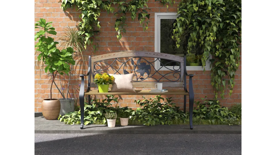Garden wooden bench with yellow potted flowers and pillow against red brick wall with ivy