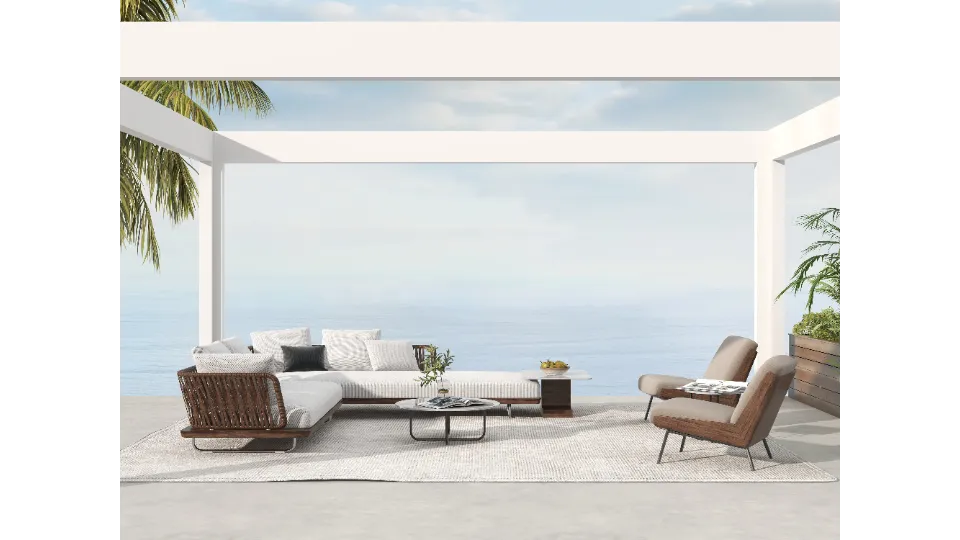 White outdoor patio overlooking the sea with woven sofa chairs and a light colored rug